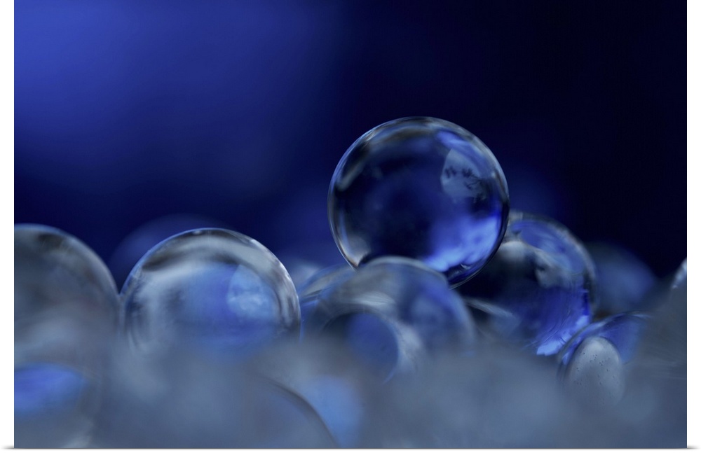 A macro photograph of a stack of blue clear spheres.