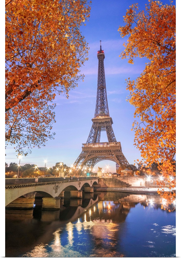 Early morning for the Eiffel tower in Paris, facing the Jena bridge with green trees around and lights.