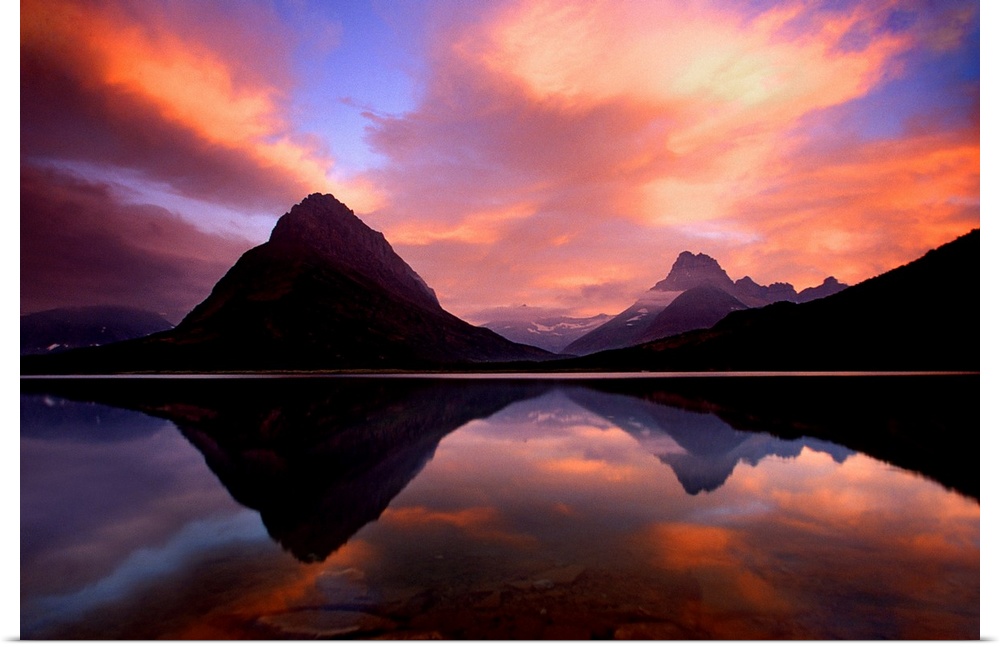 Stunning photo of the sunset over the mountains and water at Glacier National Park in Montana.