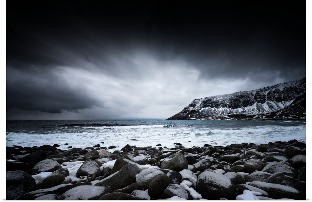 A photograph of a rugged winter landscape under a sky of dark clouds.