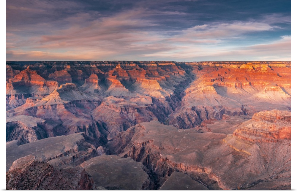 Layered bands of red rock glowing in sunset in the South Rim of Grand Canyon National Park, Arizona.