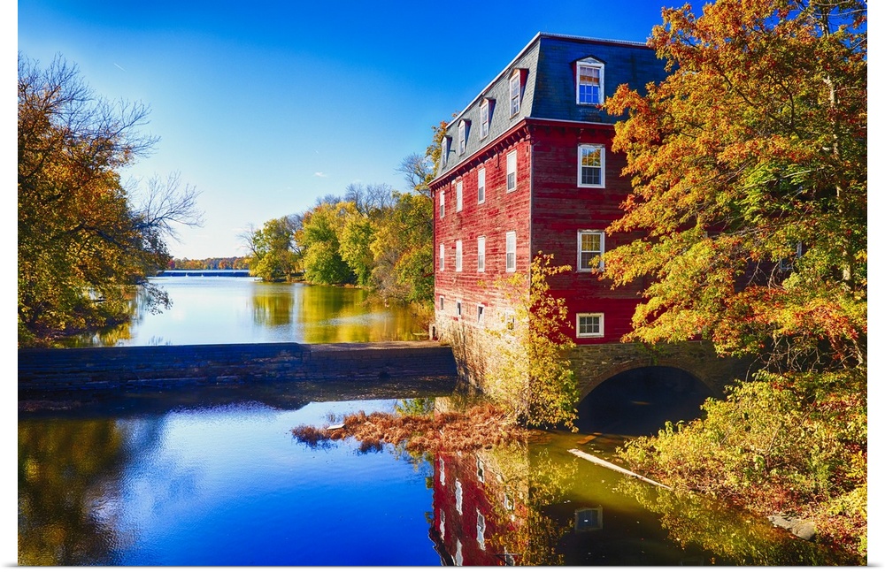 Red grist mill at the edge of the water at Lake Carnegie, New Jersey, in the fall.
