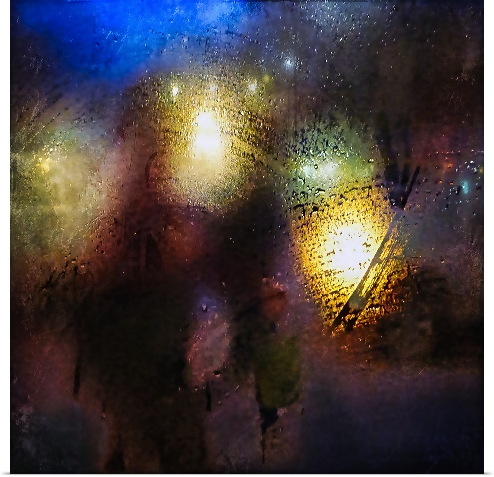 Abstract photograph of blurred street lights seen from behind a rain-covered window at night.