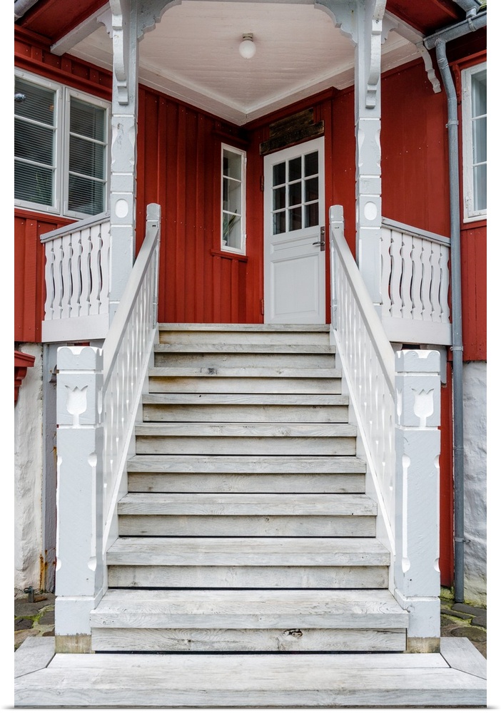 Staircase leading up to the entrance of a red house.