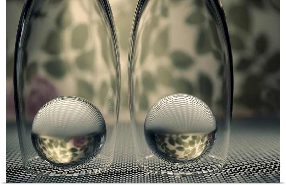 Two glass marbles underneath champagne flutes reflecting the bottom  surface and background onto them.