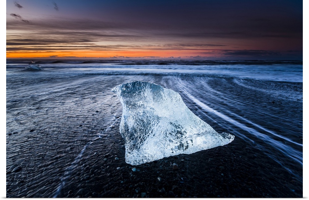 An iceberg laying on the beach near Jokulsarlon, Iceland, captured during sunrise.