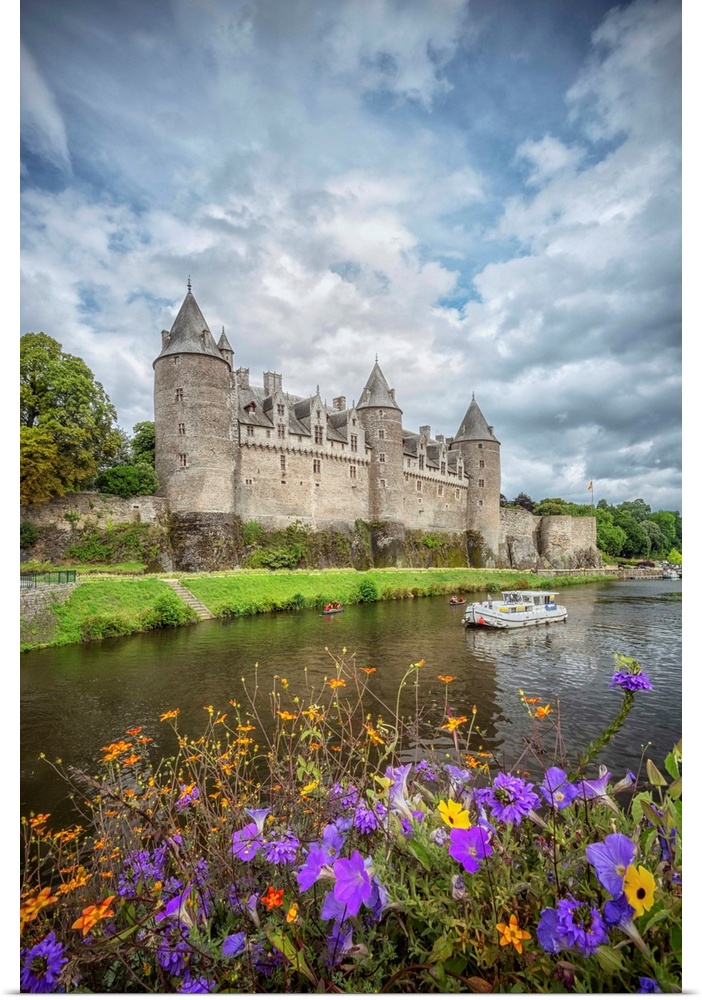 View of a medieval castle from across the river with flowers.