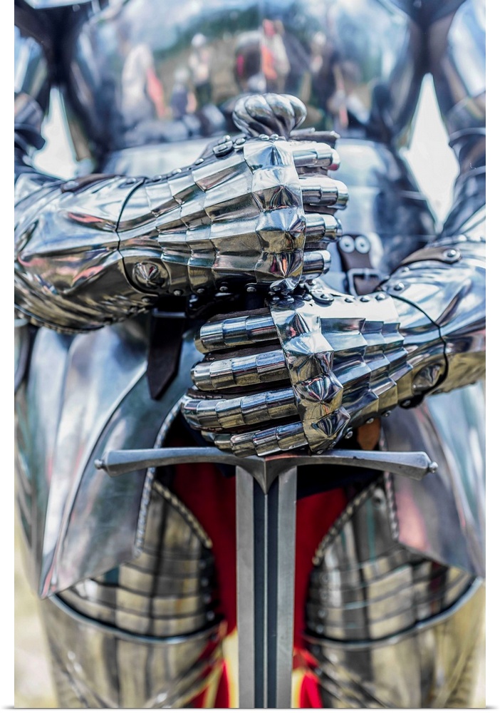 A photograph of a close-up on a suit of armor holding a sword.