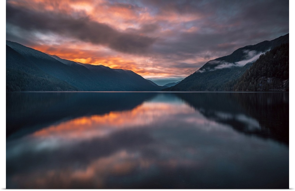 Long exposure of Crescent Lake of Olympic National Park in a fiery sunset.