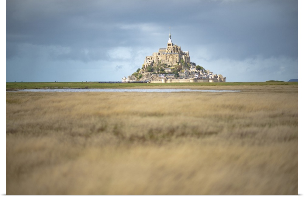 Mont Saint Michel in France in the middle of the meandres under a blue sky.