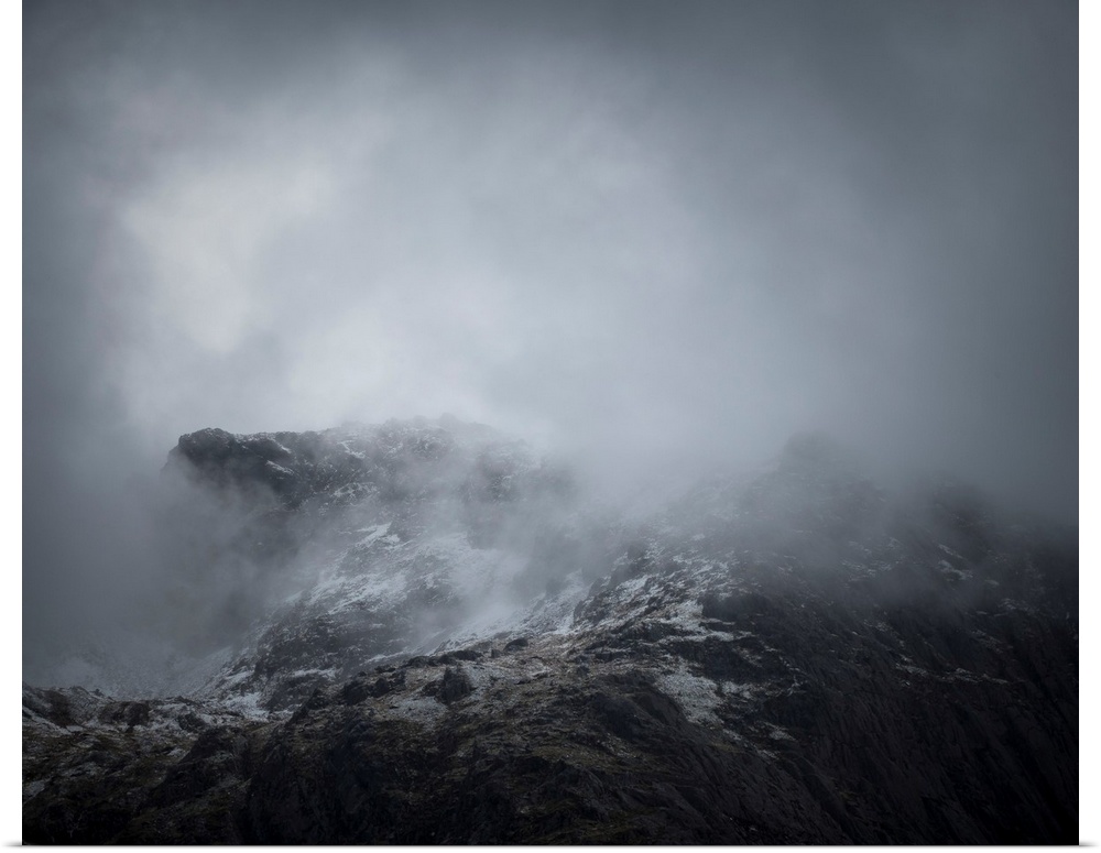 Fine art photo of the side of a mountain covered in a deep fog.