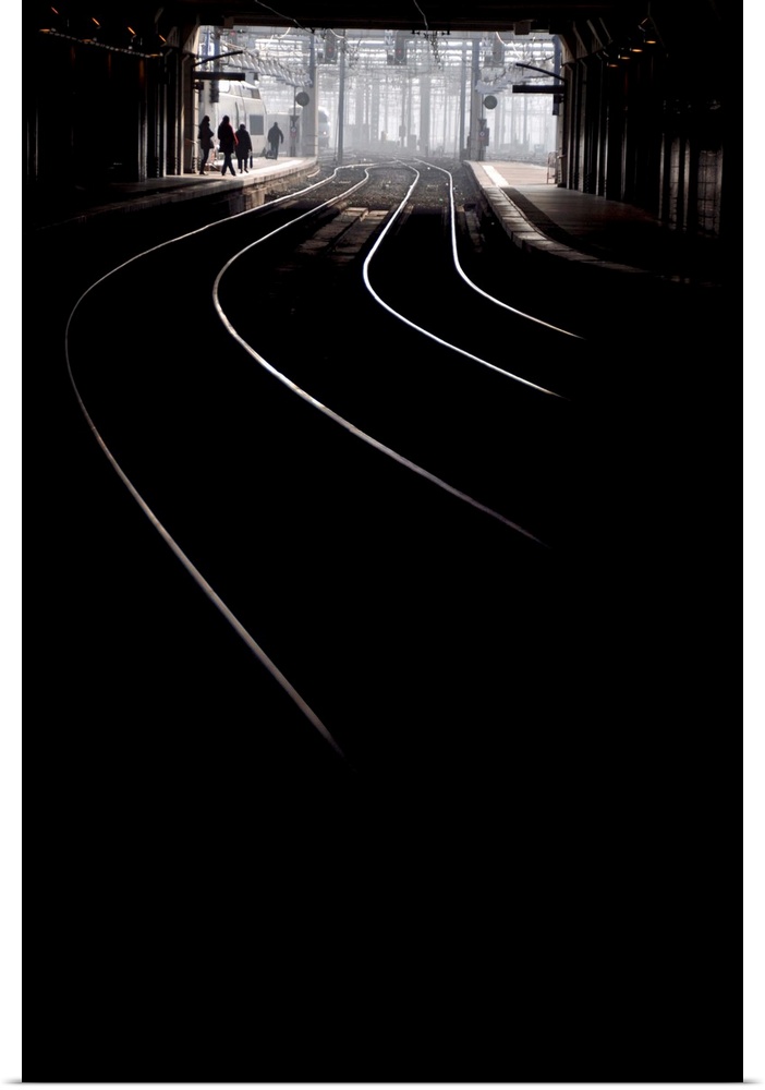 Vertical black and white picture inside Montparnasse Railway station in Paris, France, some lighting tracks.
