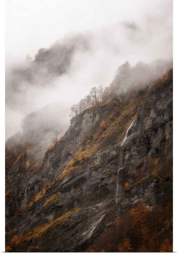 Vertical view of a moutain in Sixt-Fer-a-Cheval area in the French Alps, some fog and a little waterfall in the middle of ...