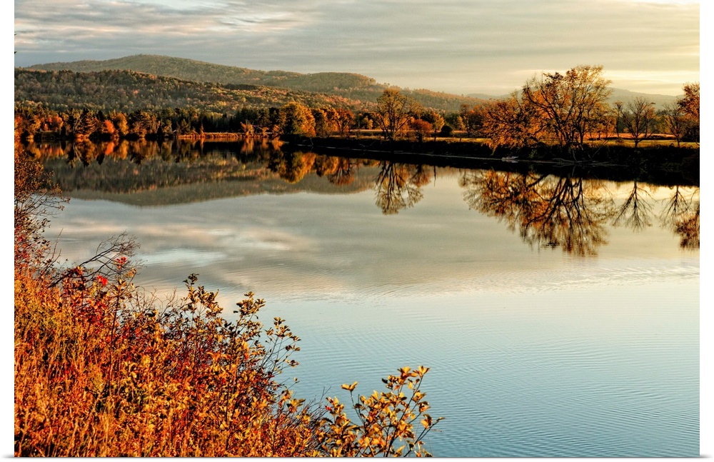 Fine art photo of a calm lake at dusk with an autumn forest in the distance.