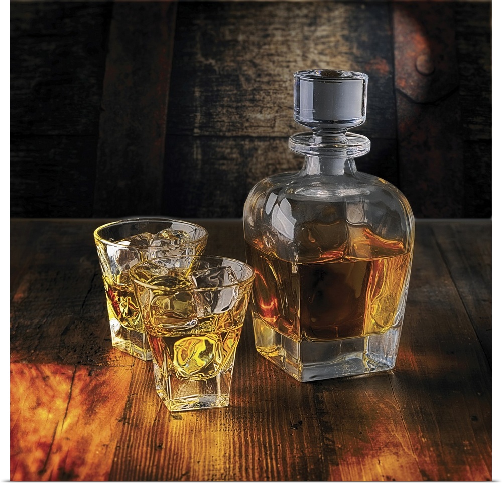 A Whiskey Bottle and Two Glasses on the Rocks on a Wooden Table.