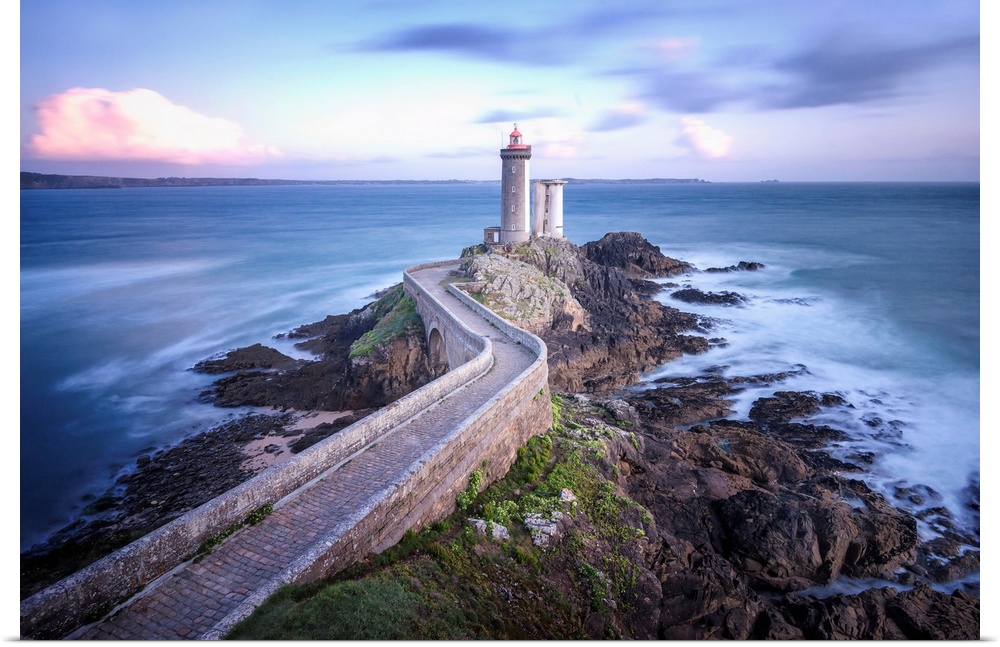 Fine art photo of a lighthouse at the end of a rocky peninsula in France.