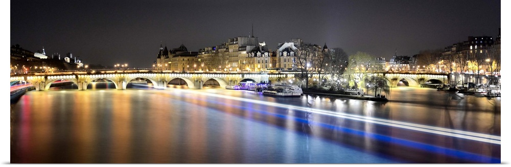Night long time exposure view of Paris from pont des arts bridge on Seine river with lignting bridge pont neuf in the back...