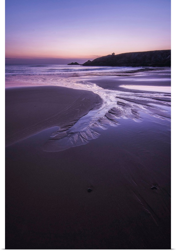 Beach at sunset in Port Blanc area in Quiberon, pink an violet colors, France, a vertical view.
