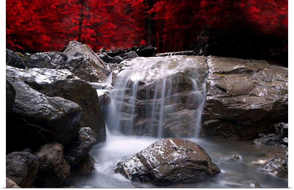 A waterfall in front of a red autumn forest