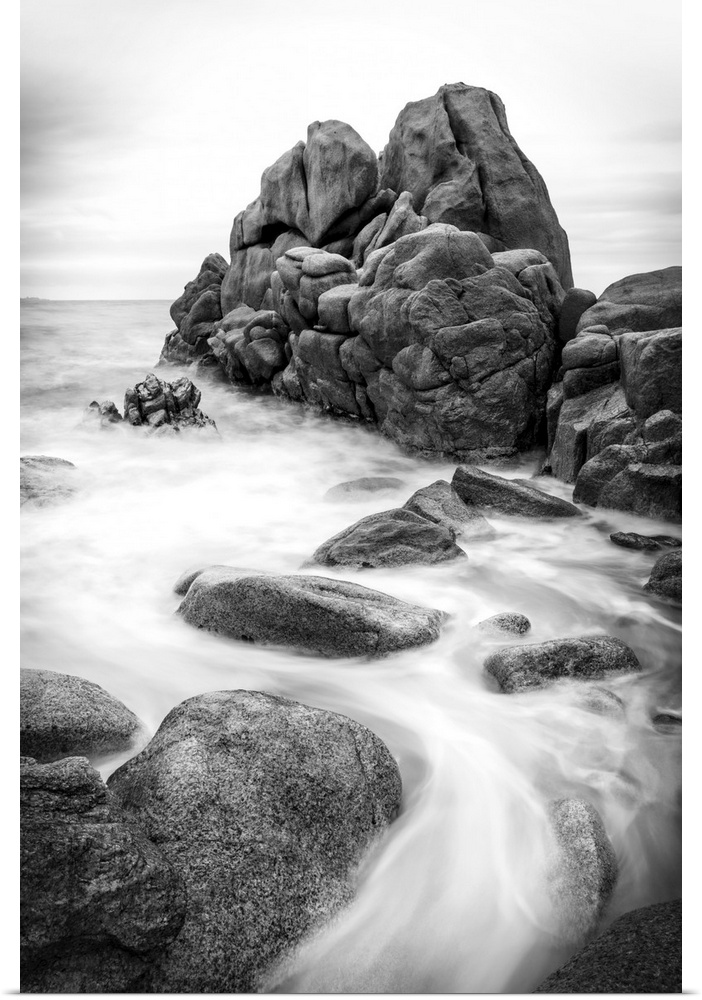 A black and white photograph of a rocky coastline.
