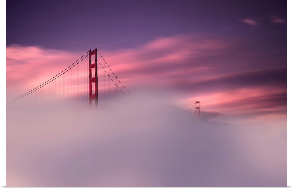 A sunset obscured by dense fog and the Golden Gate Bridge rising out of the mist in this landscape photograph.