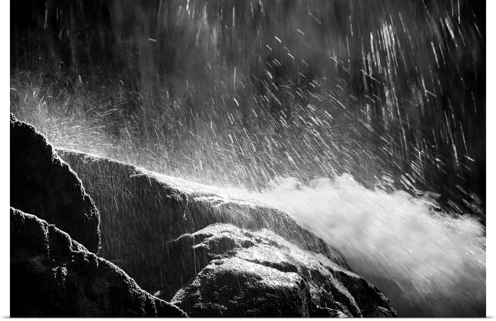 Black and white photograph of water falling from the top and rushing down rocks.