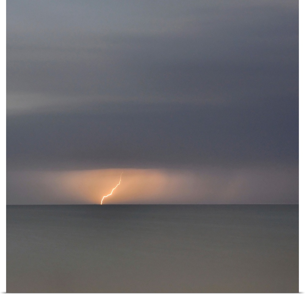 Square picture of a storm flash above a long time exposure sea.