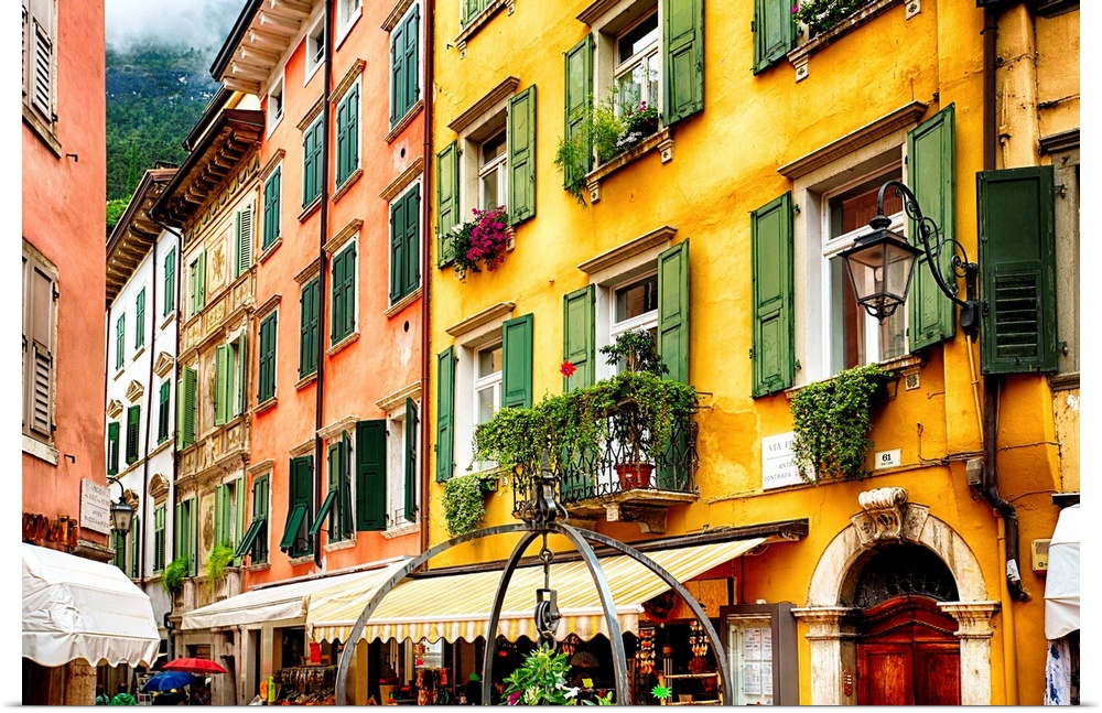 Fine art photo of the brightly colored buildings and window shutters of an Italian street.