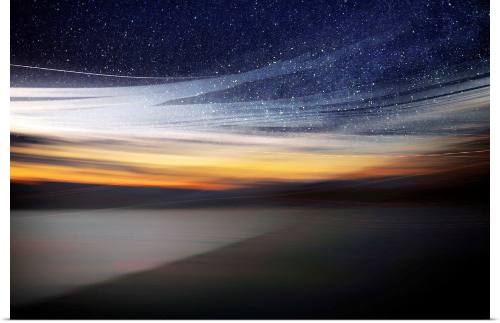 Fine art photo of a starry night sky over the light of the setting sun from the coast.