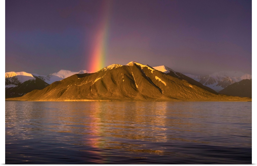 Fine art photograph of a rainbow over a mountain on the Norwegian coast.