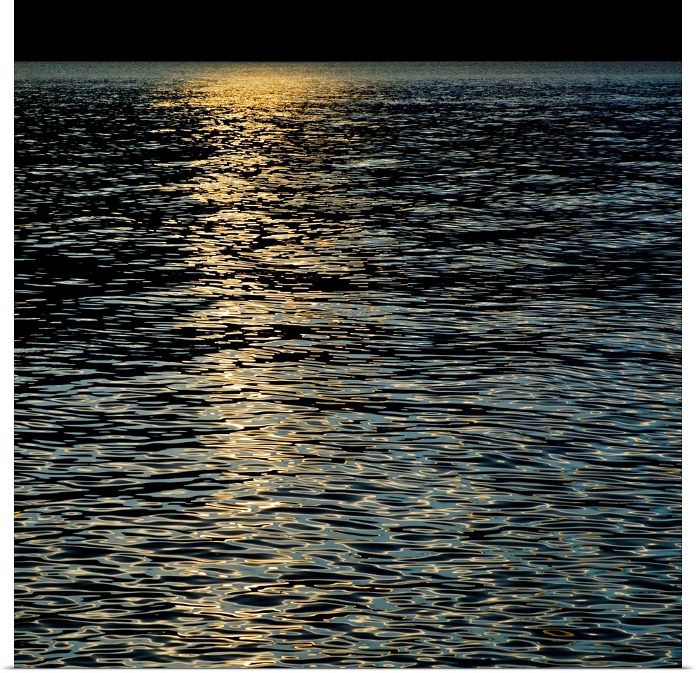 Sunlight shining on the rippling waters of the sea, creating an abstract pattern.