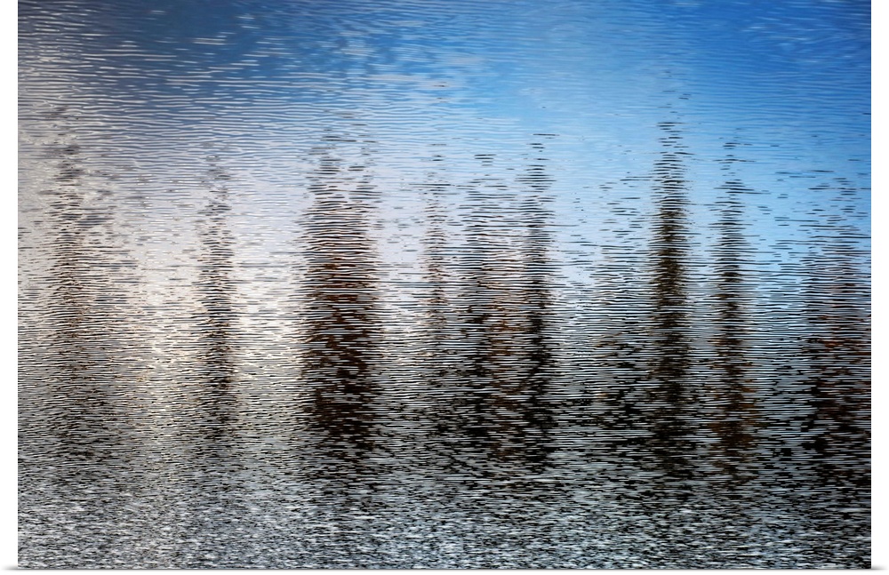 Fine art photo of abstract shapes reflected in the rippling water of a lake.