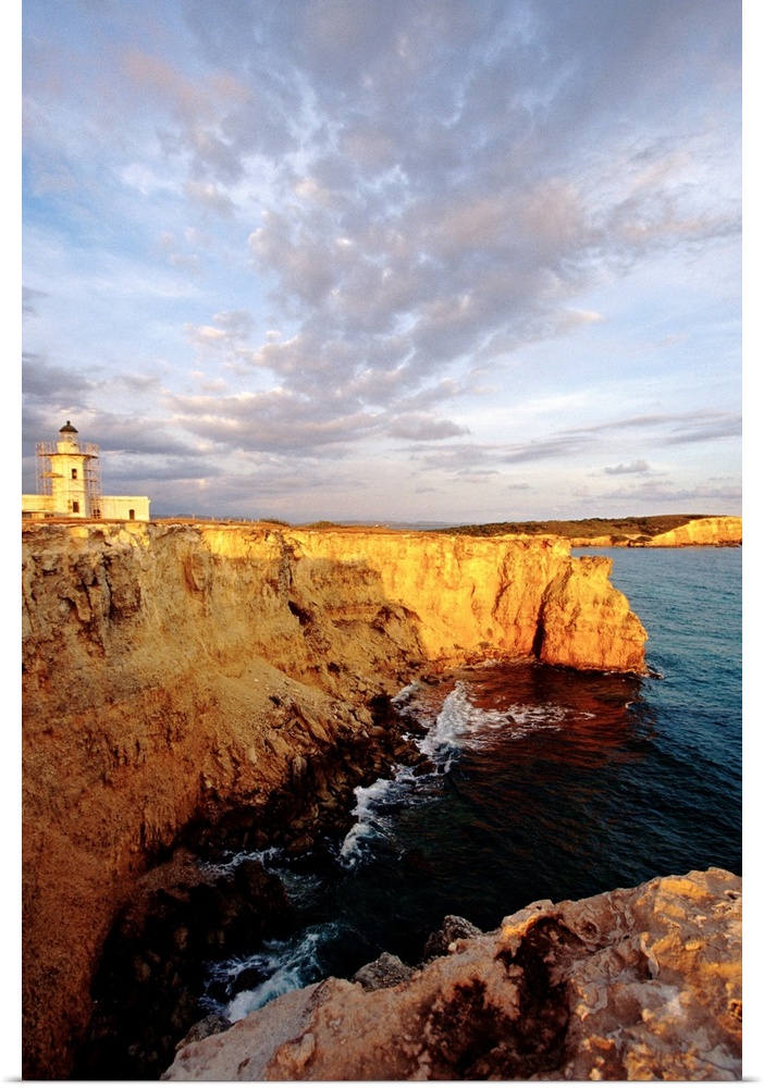 Photo on canvas of a lighthouse on top of a cliff overlooking the ocean.