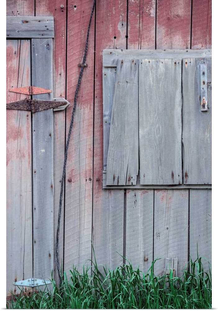 Closeup of the side of a weathered barn with fading colors.