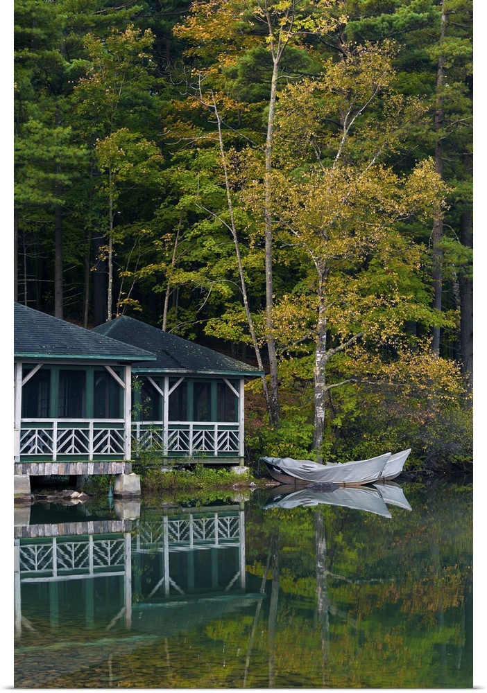 Early morning scene of a beautiful and colorful lakeside boathouse with ornate white railings surrounded by green and gold...