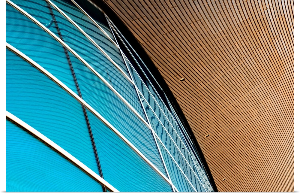 A photograph of a close-up of a curved building exterior with blue windows.