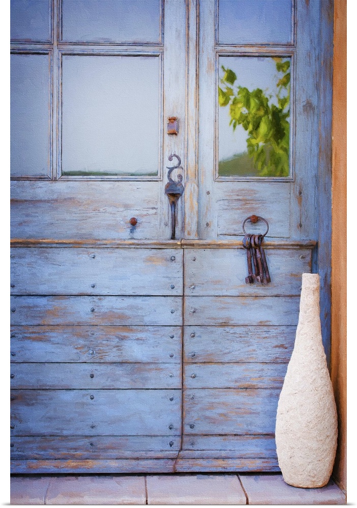 A photograph of a tall vase sitting in front of a blue cottage door.