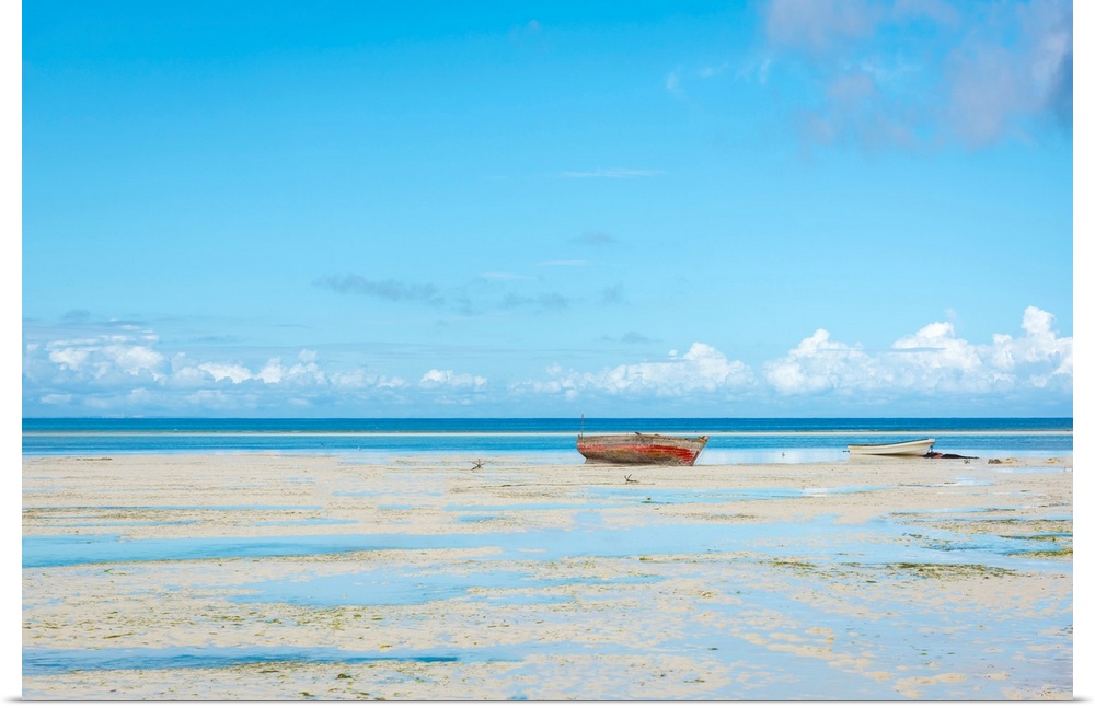 Photograph of a calm sea with a row boat along the shoreline.