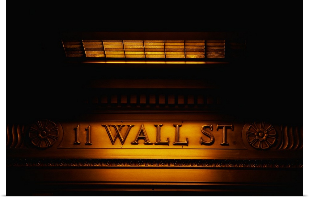 Large canvas photo of an engraved financial district sign that is dimly lit around its edges.