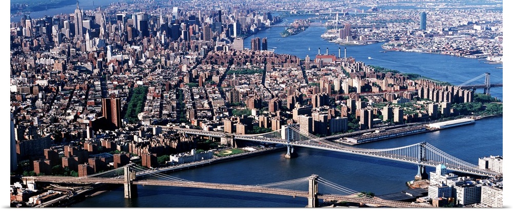 Aerial panorama of suspension bridges and bustling New York City metropolis.