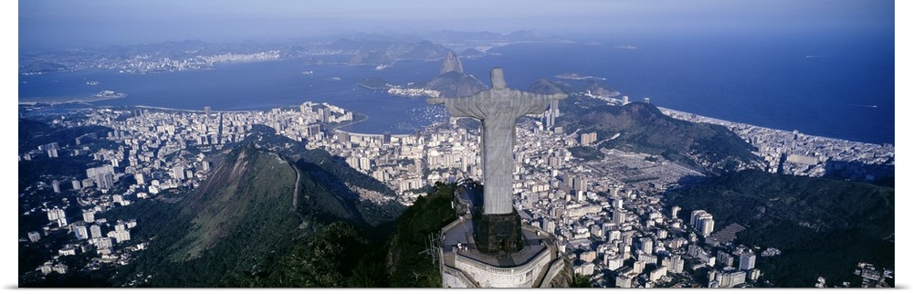 Giant, landscape photograph of the back of Christ the Redeemer statue overlooking Rio de Janeiro, Brazil.