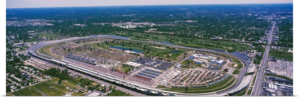 Motorsport arena in a flat Midwestern landscape, straight roads intersecting green patches and suburban neighborhoods.