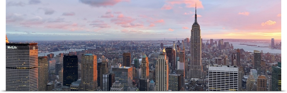 Panoramic canvas of the NYC cityscape seen from above with a beautiful sunset and views of the water in the distance.