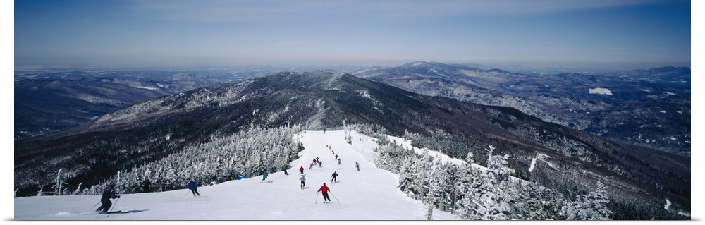 This is a panoramic photograph of skiers heading down a mountain covered with powdery snow in the Appalachian Mountains.