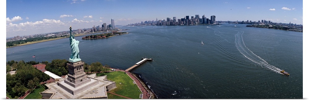 Panoramic photograph of iconic "Big Apple" monument and waterfront under a cloudy sky.