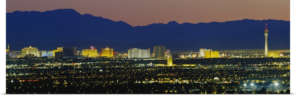 Panorama of Las Vegas skyline with the Rocky Mountains in the background at night.