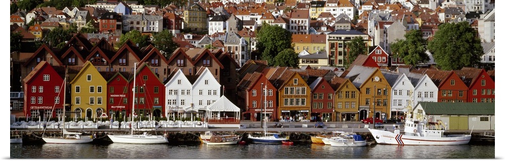 This is a panoramic photograph of a coastal town in Northern Europe lining a harbor full of boats.