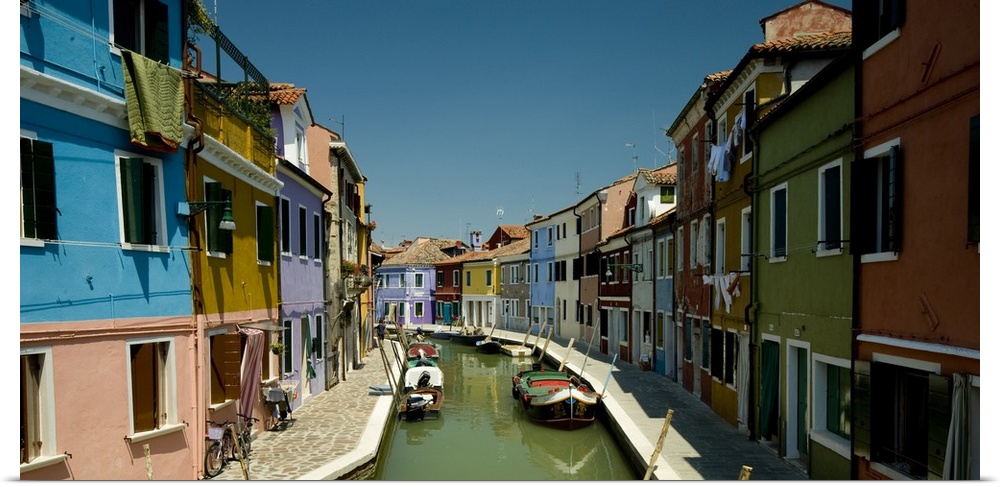 Colorful buildings line either side of a canal in Italy.