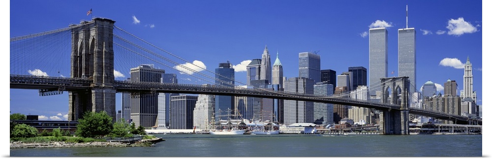 The World Trade Center buildings rise over the city skyline near the large suspension bridge in the famous United States c...