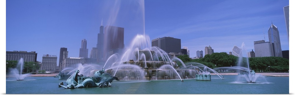Landscape, close up photograph of Buckingham Fountain during the day, the skyscrapers of Chicago in the background, beneat...